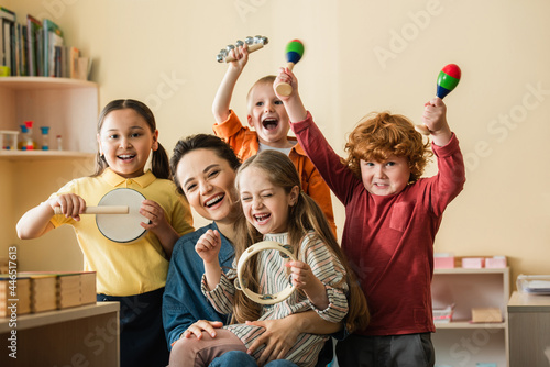 Fotografia, Obraz excited multiethnic kids playing musical instruments near happy teacher