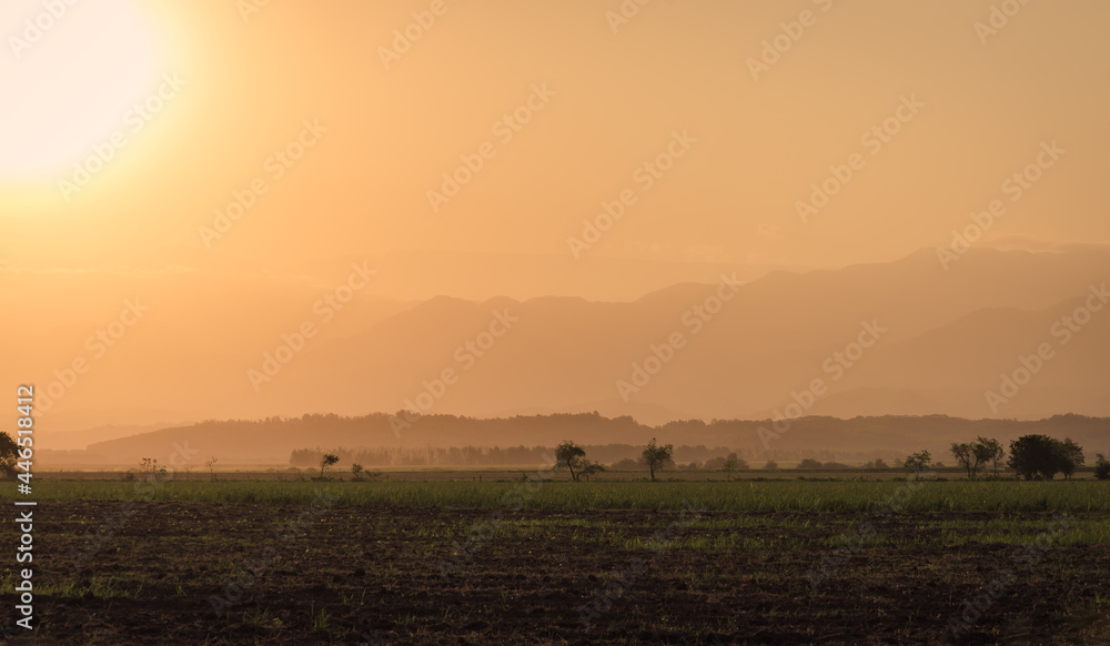 Sunset over fields and hills