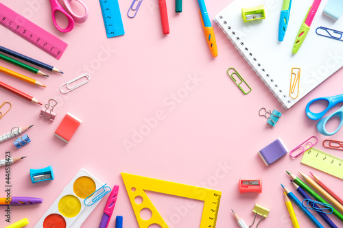 School supplies on a pink background with copy space, top view. Back to school concept.