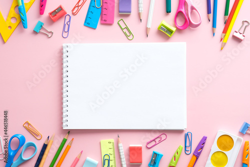 School supplies and blank paper notepad on pink background. Back to school concept, Top view, flat lay,