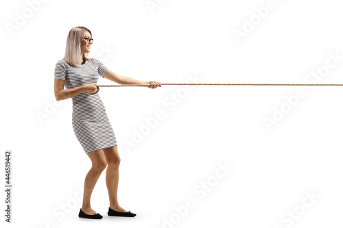 Full length profile shot of a young woman pulling a rope