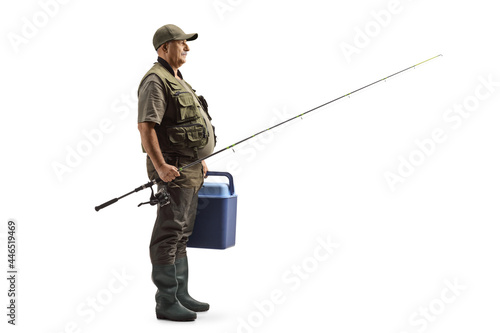 Full length profile shot of a fisherman holding a fishing rod and a portable fridge