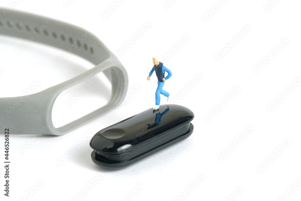 Miniature people toy figure photography. Run jogging monitoring app. A young men running above smartwatch, isolated on white background Miniature people toy figure photography. Run jogging monitoring app. A young men running above smartwatch, isolated on white background