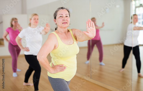 Adult people learning swing steps at dance class and smiling