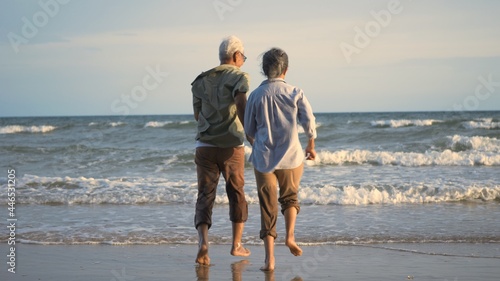 Happy Asian active senior man and woman couple lifestyle running to beach and enjoying funny, Romantic elderly enjoy travel summer vacation, plan life insurance at retirement couple concept