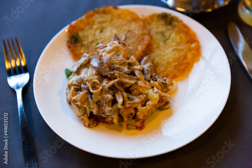 Fried beef in sour cream sauce with potato pancakes. Belarus cuisine