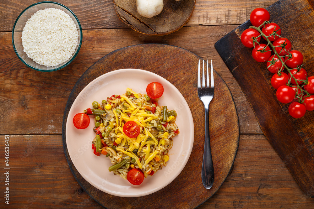 Risotto with mushrooms and cheese on a wooden background near rice and vegetables. Risotto with mushrooms and cheese on a wooden background near rice and vegetables.