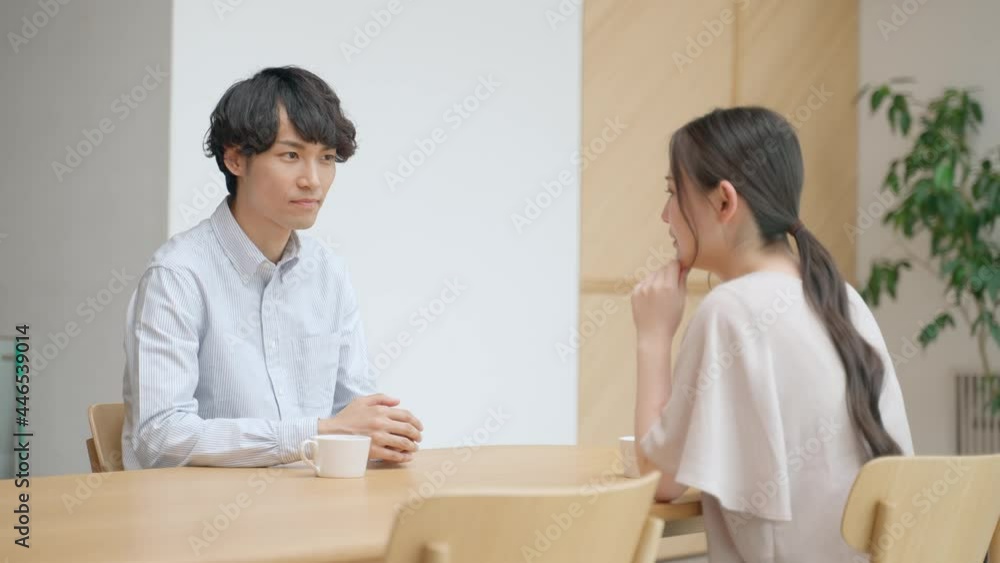 室内で会話をする若いカップル 室内で会話をする若いカップル