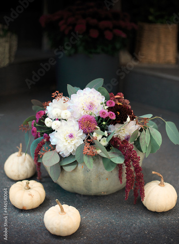 Floral bouquet in a pumpkin vase. Autumn pumpkin flower arrangement . Halloween Selective focus 