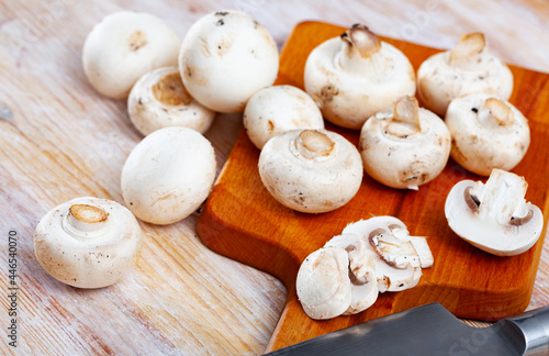 Fresh champignon mushrooms on a wooden cutting board. High quality photo