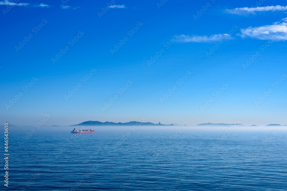 Sea landscape, sea surface. Blue sky, clouds, sunlight, rays. Empty natural scene in the open air. Blurred abstract background. Background of a sea landscape. Blue sky with clouds over the sea.