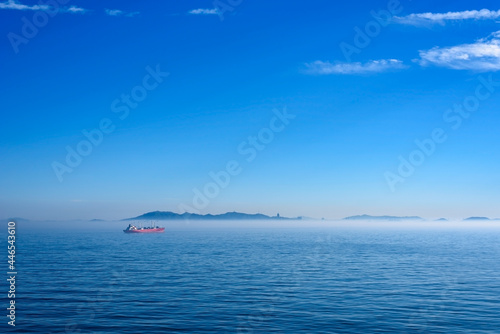 Sea landscape  sea surface. Blue sky  clouds  sunlight  rays. Empty natural scene in the open air. Blurred abstract background. Background of a sea landscape. Blue sky with clouds over the sea.