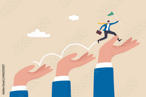 Business support or mentorship to assist employee to success, helping hand or encouragement for teammate to achieve business goal, businessman jumping up giant hand growth ladder to progress target. photo