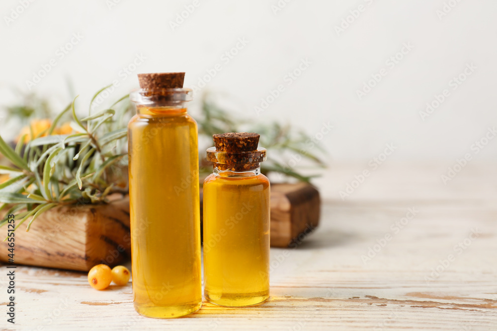 Bottles of sea buckthorn essential oil on table Bottles of sea buckthorn essential oil on table