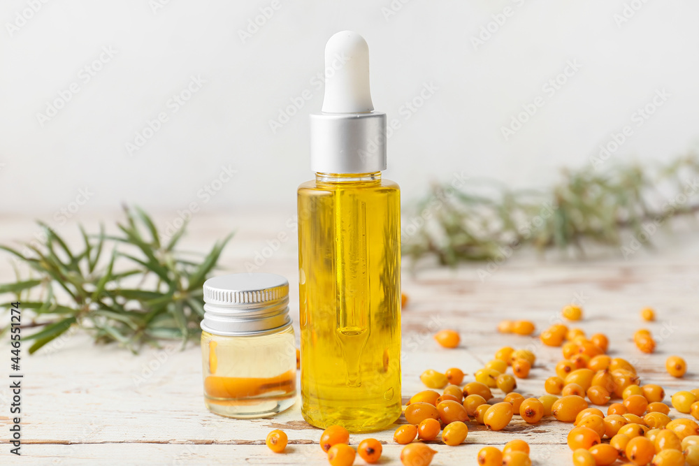 Bottles of sea buckthorn essential oil on table Bottles of sea buckthorn essential oil on table