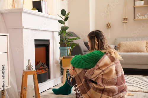 Young woman sitting near fi...