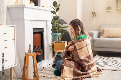 Young woman sitting near fi...