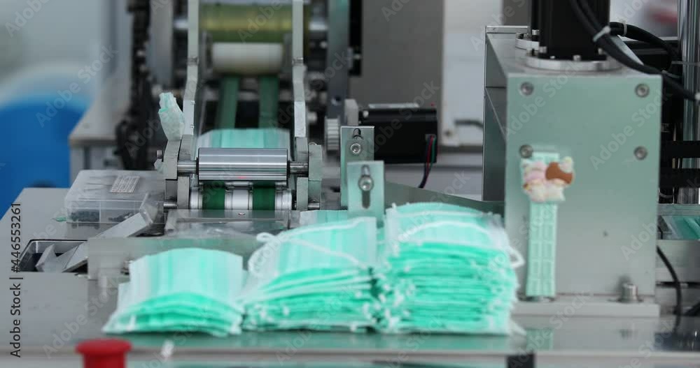 Machines are working for producing masks in a sterile factory. Production of medical masks. process of manufacturing a mask Machines are working for producing masks in a sterile factory. Production of medical masks. process of manufacturing a mask