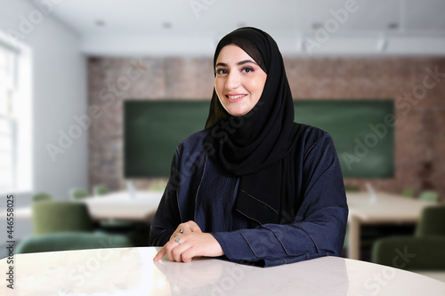 Arabic teacher portrait inside the classroom. Emirati woman on Abaya Hijab