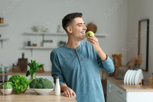 Young man eating apple in k...