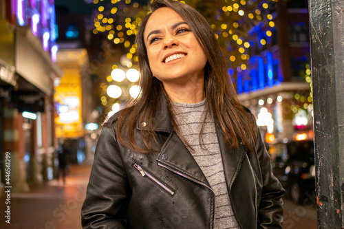 夜の通りで楽しそうに笑うラテン系女性