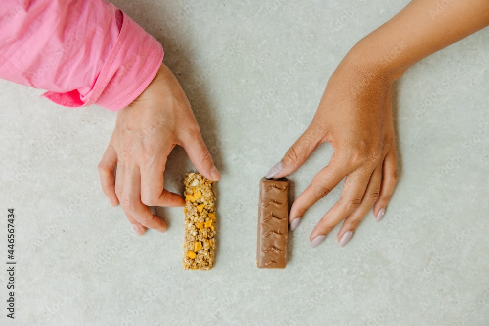 Obraz premium Person holding a chocolate bar and granola bar
