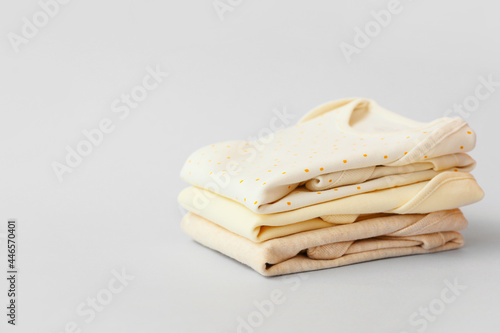 Stack of baby clothes on grey background