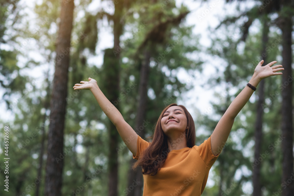 Portrait image of a happy woman with arms rising in the park Portrait image of a happy woman with arms rising in the park