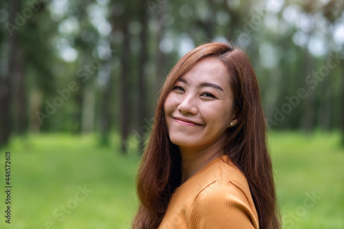 Portrait image of a beautiful young asian woman standing in the park