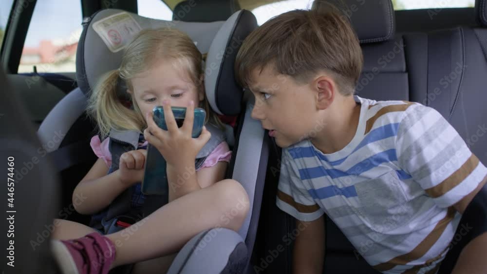 Video of children with a mobile phone in the car. Shot with RED helium camera in 8K. Video of children with a mobile phone in the car. Shot with RED helium camera in 8K.