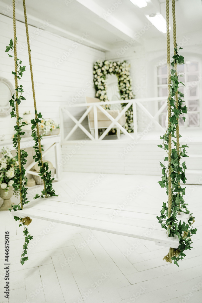 Naklejka premium White swing with artificial flowers