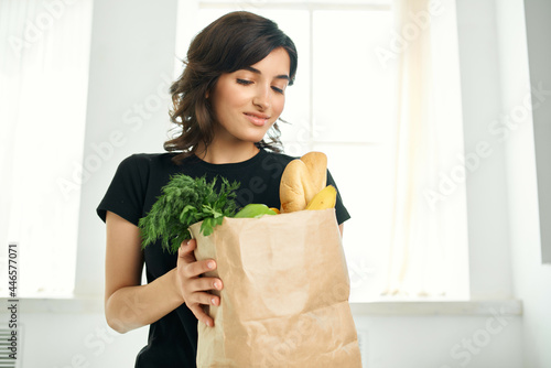 woman in black t-shirt package with products vegetables fruits healthy food