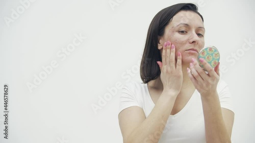 4k video of woman having skin problems looking in the mirror.