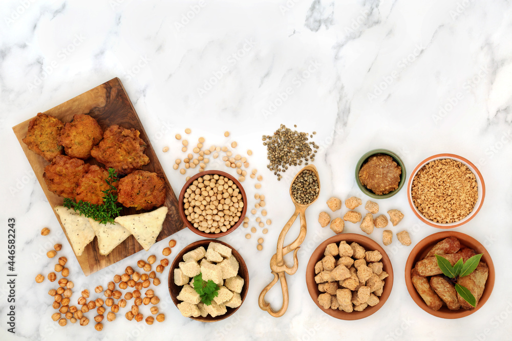 Vegan health food for a healthy diet with tofu bean curd, bhajis, samosas, tvp, miso, soy bean, chickpeas. Plant based health foods for ethical eating concept. On marble, flat lay top view. Vegan health food for a healthy diet with tofu bean curd, bhajis, samosas, tvp, miso, soy bean, chickpeas. Plant based health foods for ethical eating concept. On marble, flat lay top view.