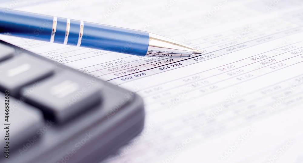 Pen point on bank statement with calculator Pen point on bank statement with calculator