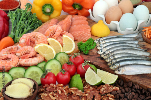 Pescatarian healthy food concept for an immune system boosting balanced diet high in protein and omega 3 with a collection of vegetables and fruit. Foods to help lower cholesterol and blood pressure.