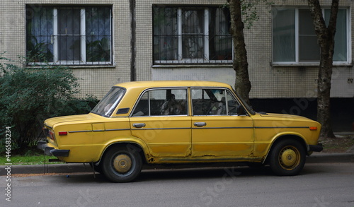 An old yellow Soviet car in the courtyard of a residential building, Podvoysky Street, St. Petersburg, Russia, July 2021