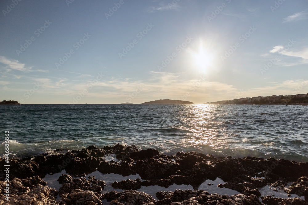 Beautiful summer sunset over small town of Rogoznica, with open Adriatic sea splashing the rocky shore Beautiful summer sunset over small town of Rogoznica, with open Adriatic sea splashing the rocky shore