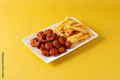 Traditional German currywurst on yellow background. Suasages with ketchup and curry photo