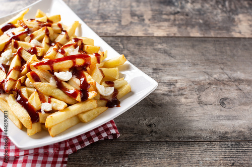 Traditional Canadian Poutine on wooden table. Copy space