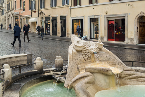 Close-up view of Fontana della Barcaccia (Fountain of the Ugly Boat) in Piazza di Spagna (spain square) in a rainy day.
