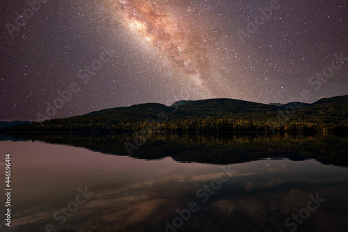 Starry night sky. The milky way is reflected in the lake. The mountains are sleeping peacefully. 