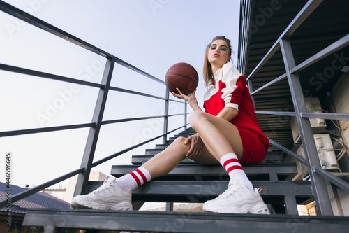 Fototapeta Naklejka Na Ścianę i Meble -  Beautiful adorable young girl in retro 90s fashion style, outfits posing on stairs, outdoors. Concept of eras comparison, beauty, fashion and youth.