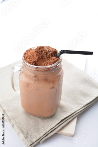 cold iced chocolate milo dinosaur with coco powder in glass jar white background asian beverage halal menu