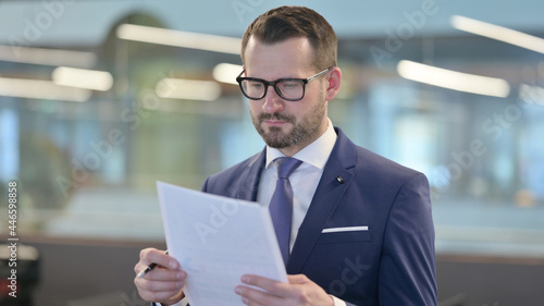 Portrait of Middle Aged Businessman Reading Documents