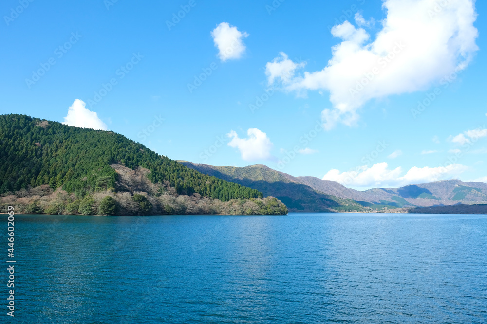 Range of mountain covered with green forest against blue clouds sky background in sunny day,Lake Ashi or Hakone Lake in Japan. Range of mountain covered with green forest against blue clouds sky background in sunny day,Lake Ashi or Hakone Lake in Japan.