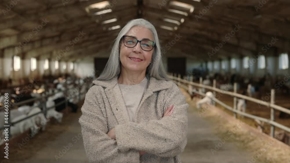 Farm worker posing with crossed arms at ranch with goats Farm worker posing with crossed arms at ranch with goats