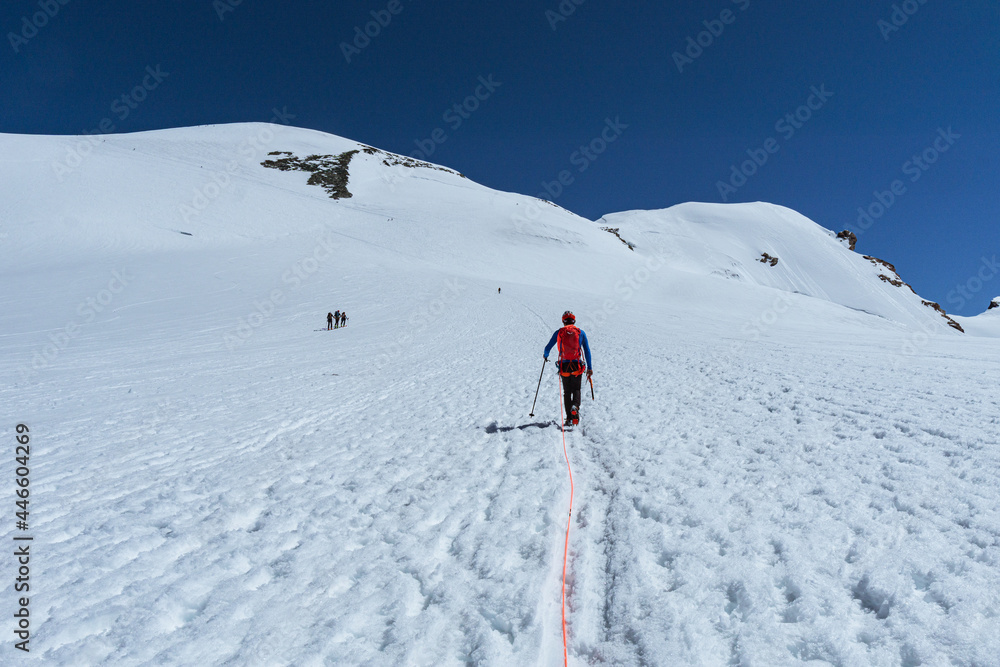 An alpinist climbing to one of the many peaks of the Monte Rosa massif, near the town of Cervinia, Italy - June 2021