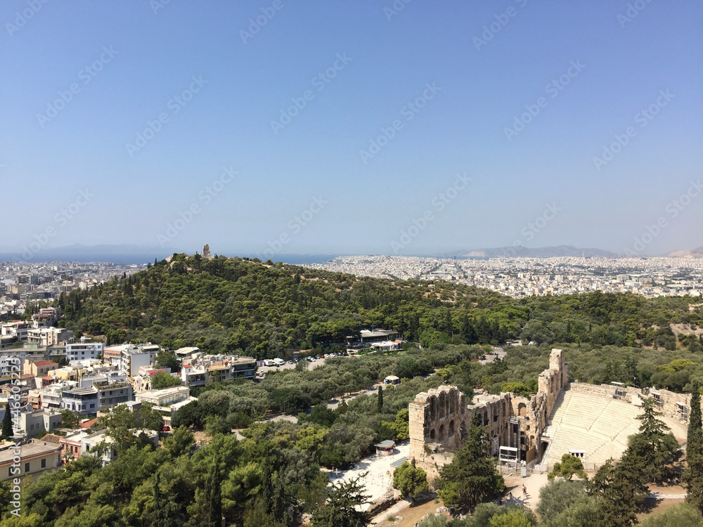 View of the Philopappos Monument on Mouseion Hill (Hill of the Muses) and the Odeon of Herodes Atticus seen from the Athenian Acropolis in Athens, Greece.