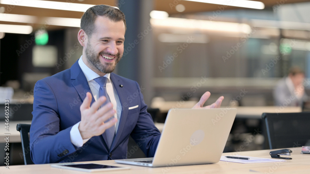 Successful Middle Aged Businessman Celebrating on Laptop at Work